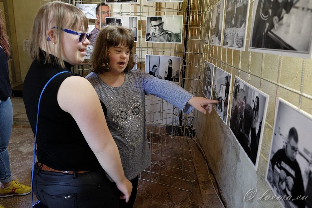 Visitatori che osservano fotografie in mostra